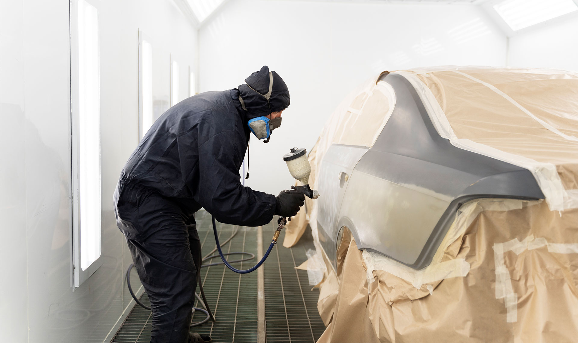  Carrossier ponçant un panneau de carrosserie dans un atelier à Chambly 