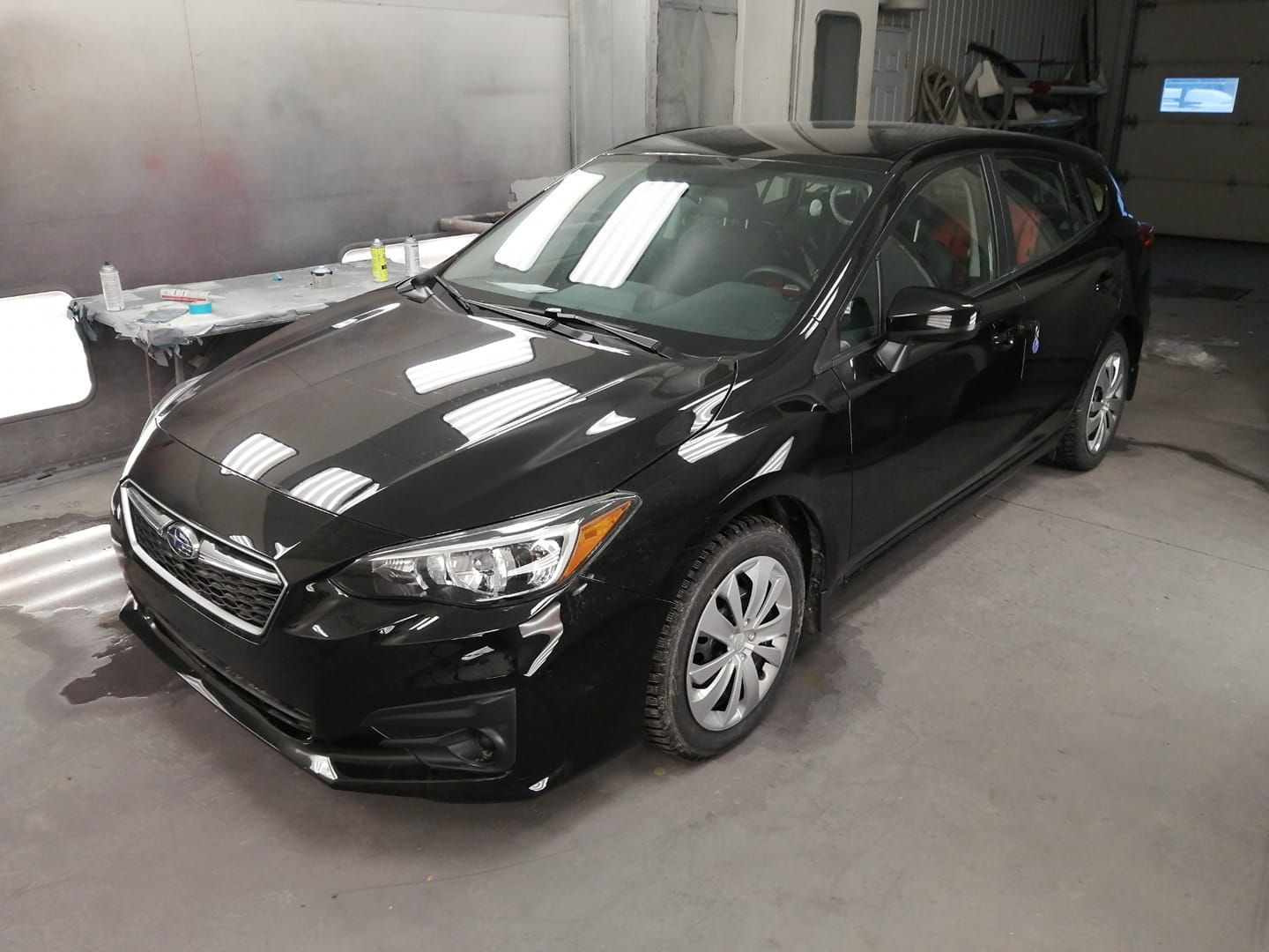 Panneaux et pare‑chocs en attente de réparation dans un atelier de carrosserie en Beauce 